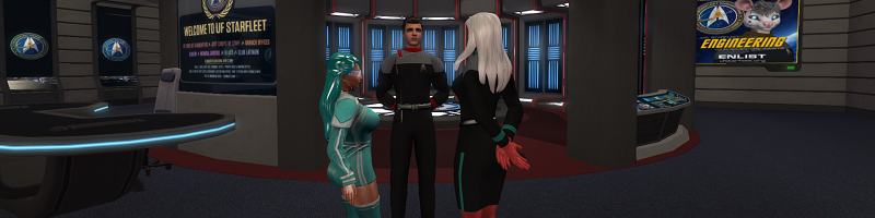 Three people stand talking together in a Star Trek themed building. A transporter room sits behind them. A man stands in the middle with two women on either side. The man and the woman on the right are wearing dark, long sleeved Star Trek style uniforms. The woman has long white  hair and the man short brown. The woman on the left is wearing a cyan tunic with white piping and a visor. Her hair is long shiny cyan.