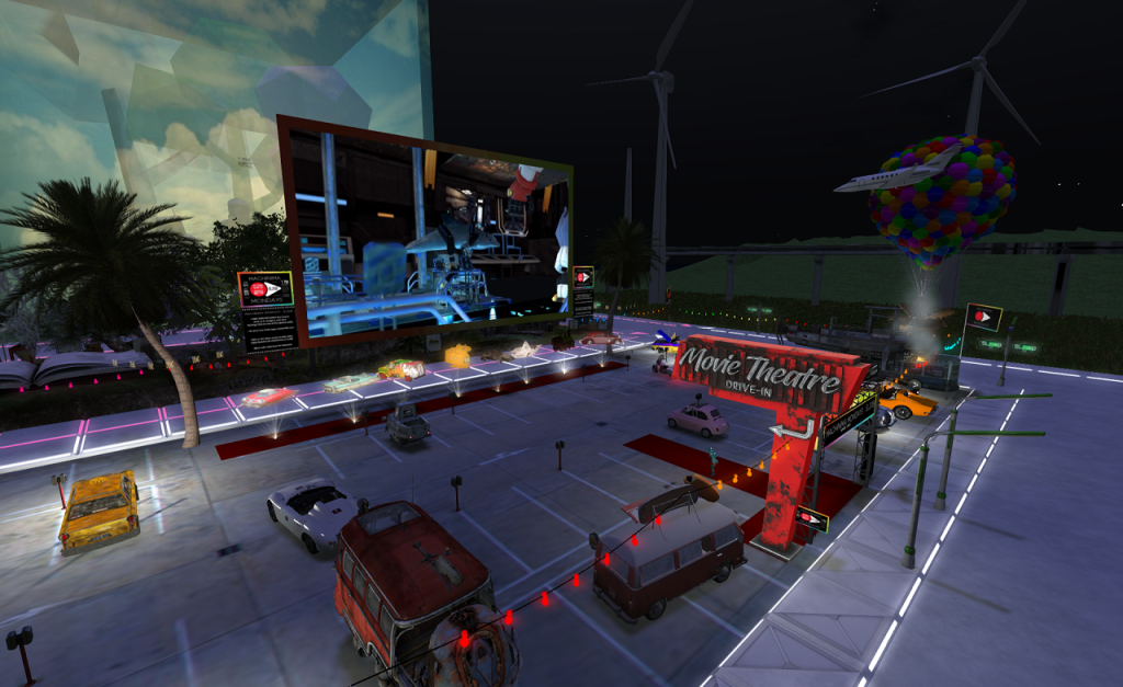 It's nighttime. A drive[in theater with a paved lot is spread out before the viewer. In the foreground, a beat up "Movie Theatre: Drive-in" sign points toward the lot. A VW camper van is parked next to it. A few other cards are scattered through the lot. On the screen, a movie filed in Second Life is showing. A dolphin character in a mechanical walking apparatus is featured.